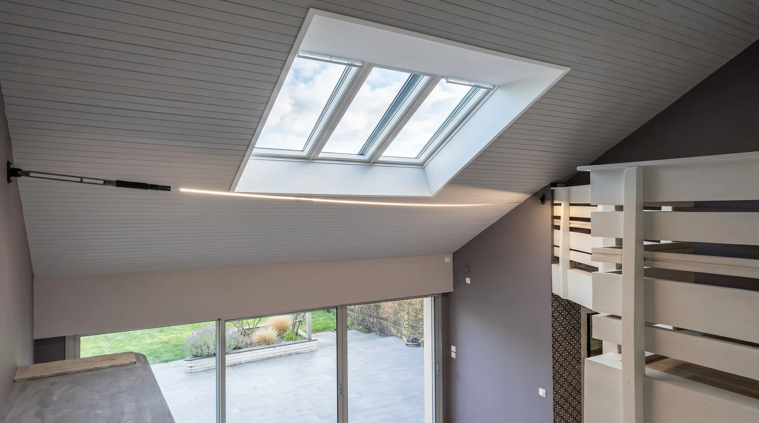 Intérieur moderne à double hauteur avec plafond incliné en lambris blanc